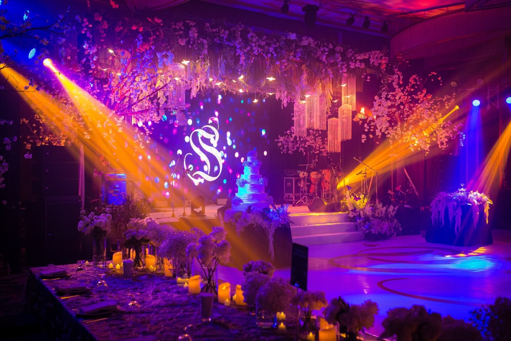 Reception colorful uplit stage at Avani+ Hua Hin Resort, Hua Hin — Indian wedding planned by Niramit Creations.